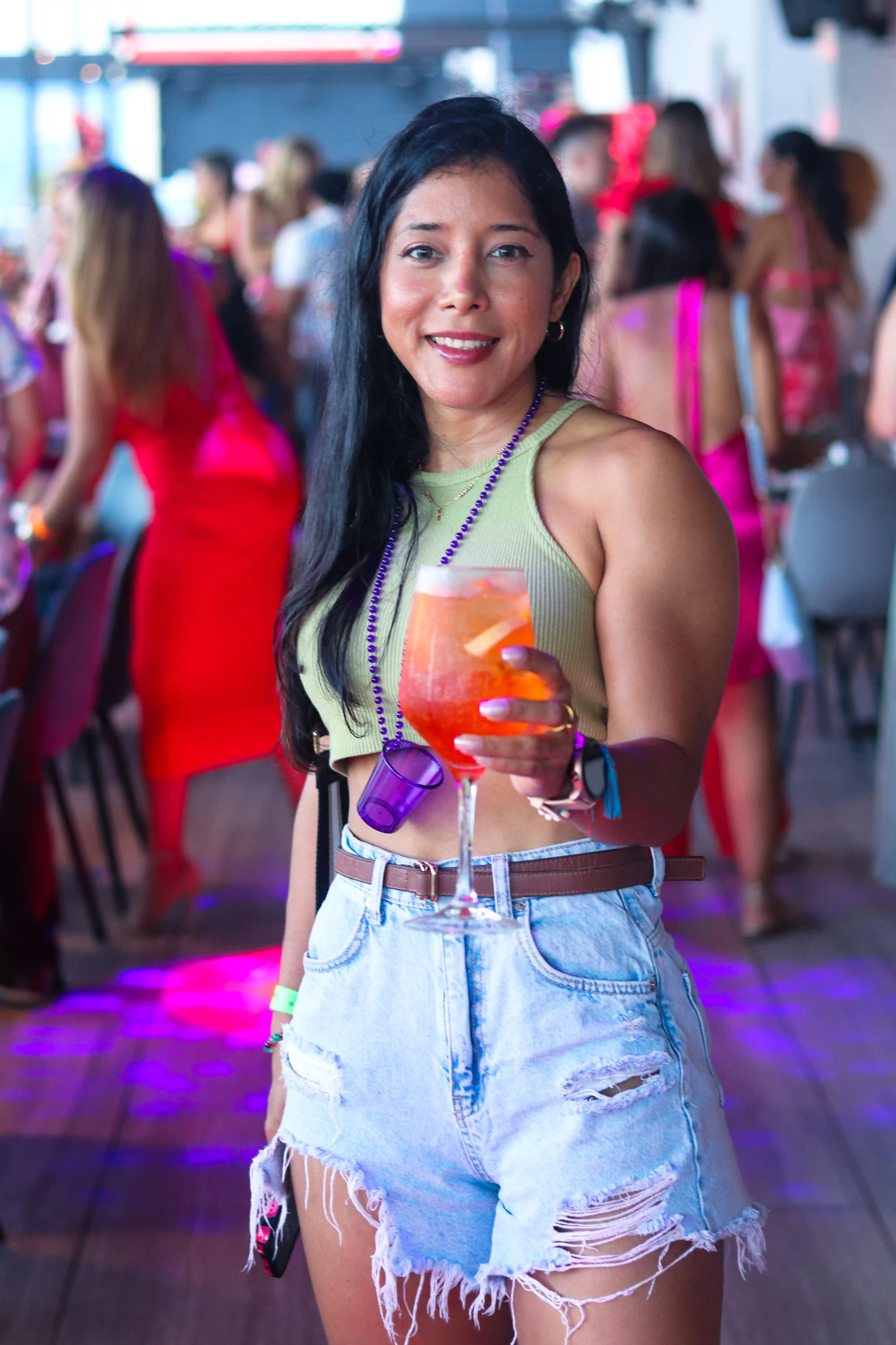 Profesional elegante en atuendo festivo, alzando su copa con alegría en una animada celebración corporativa